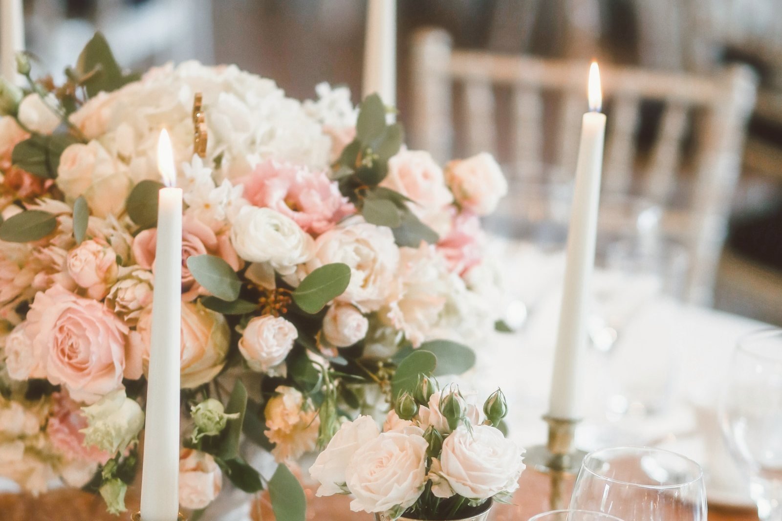 Table de mariage avec un centre de table de roses pâles et des bougies